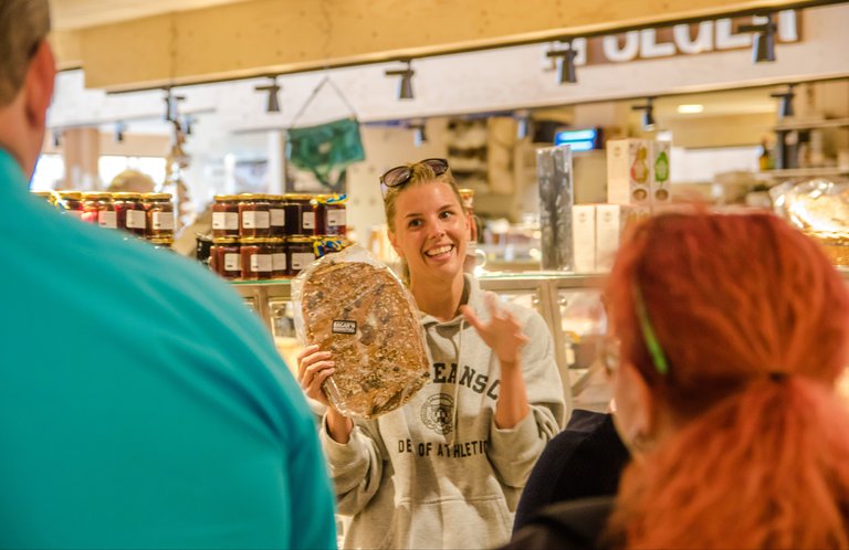 A guide telling a story to a group on a guided tour in a food market. .