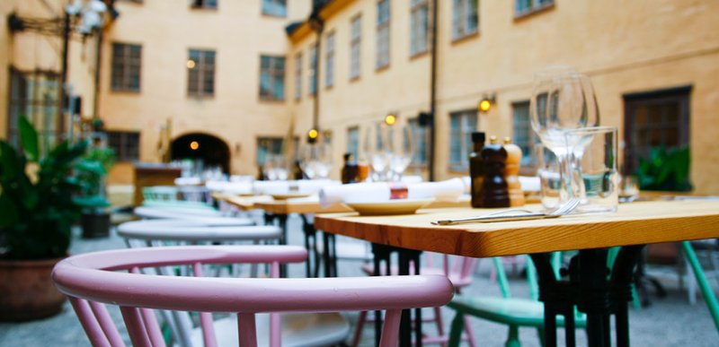 The courtyard at restaurant Häktet. Several tables are set up on the little square between the old prison buildings.