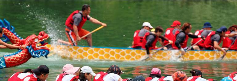 People sitting in boats, racing together.