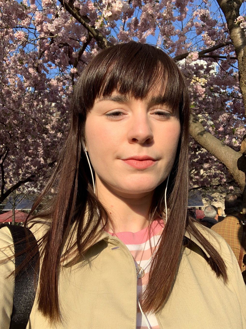 A young woman, Elena Ramirez, in front of a cherry tree in Stockholm.