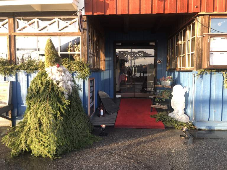 The entrance to the restaurant with Santa Claus made of Christmas tree branches.