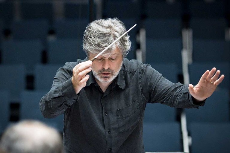 close-up photo of composer James Macmillan directing an orchestra