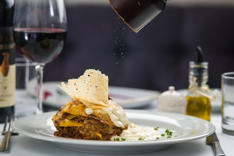 a plate with a dish and a glass of wine