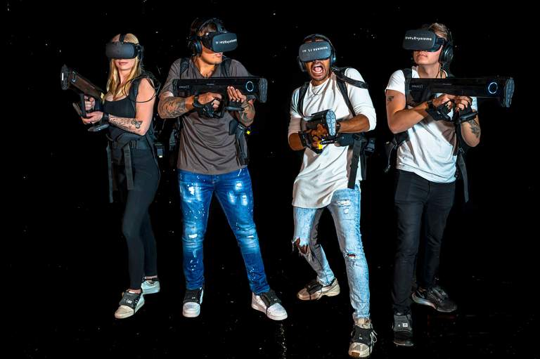 Activities in Stockholm. Four people wearing VR-headsets and holding gun-shaped game controllers at VREX, a virtual reality game center in Bromma.