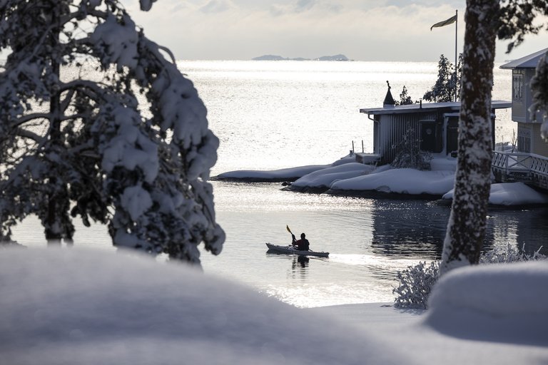 A kayak in calm waters surrounded by a rocky winter landscape