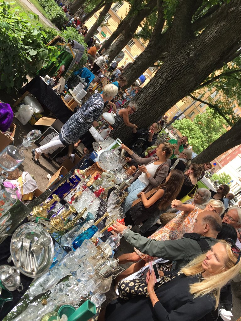 People looking at the objects on the tables at an antiques and flea market