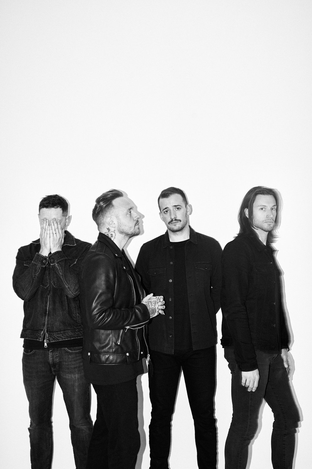 Fyra män i svarta jackor.