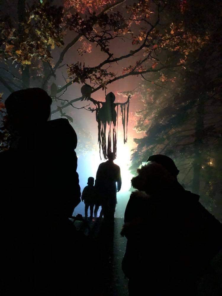 People walking in a park decorated for Halloween.