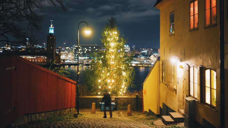 A shining Christmas tree at night in a cobble stoned alley in the historic Neighborhood Södermalm in Stockholm