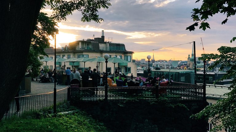 Outdoor bars in Stockholm. People sitting at the outdoor area of Södra Teatern. Sunset. Evening. Spring.