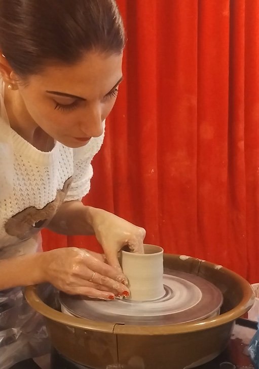 a person making an object on a a pottery machine