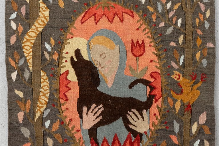 a textile artwork depicting a person with a dog