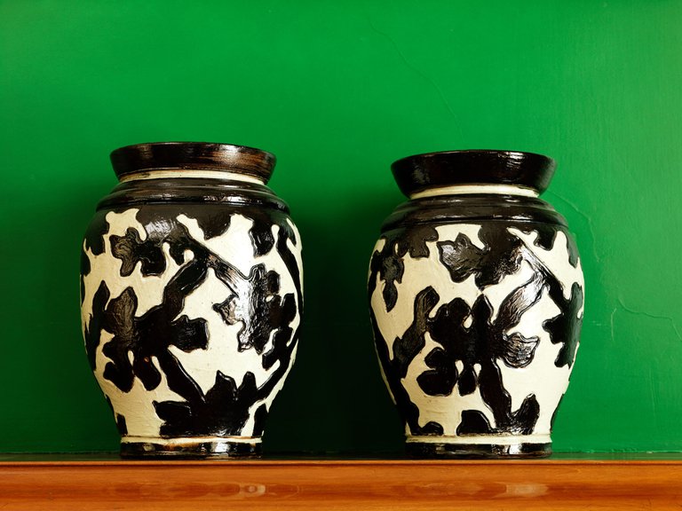 Two vases on a green background.
