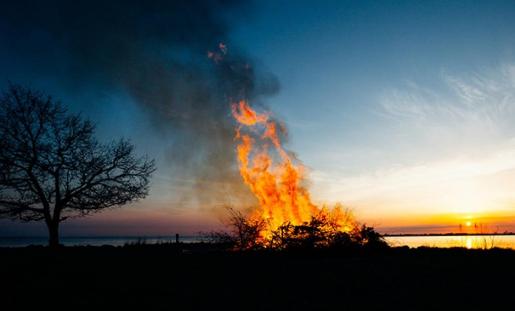 Walpurgis Night bonfire by the water. Sunset.